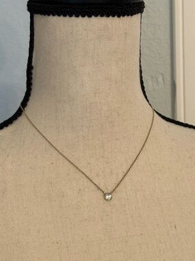 Single faux diamond necklace on gold colored chain.